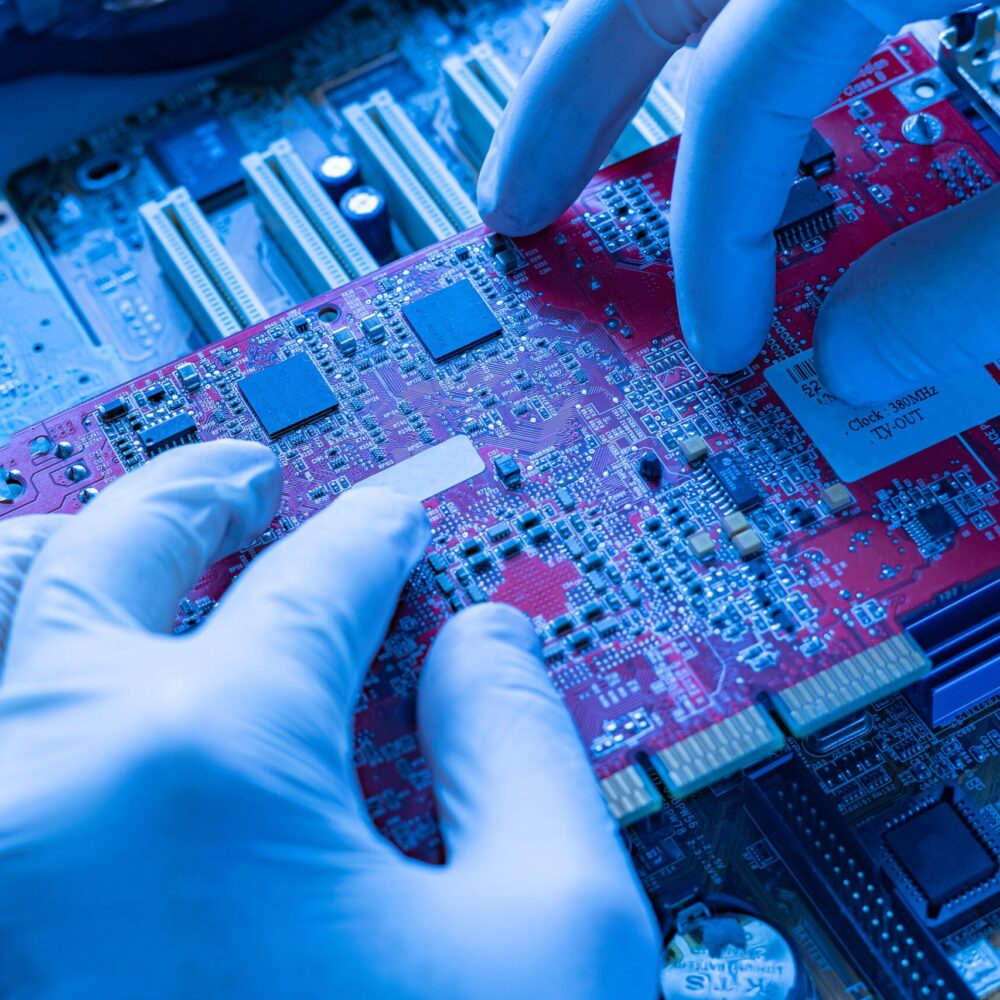 the scientist hands in gloves work with a circuit board in laboratory, close up view