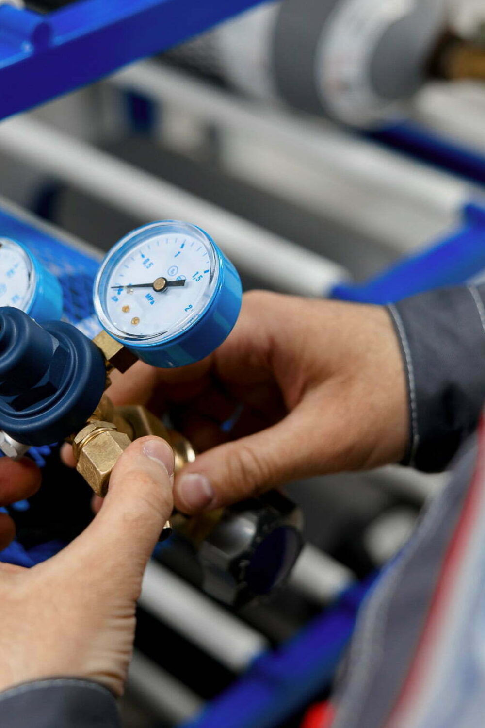 A metrology laboratory specialist takes a compressed gas cylinder for testing and verification. The man connects the pressure gauge. Analyze gas and check connections for leaks.